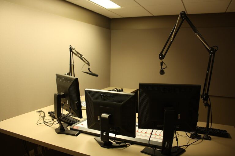 A broadcast studio desk with microphones