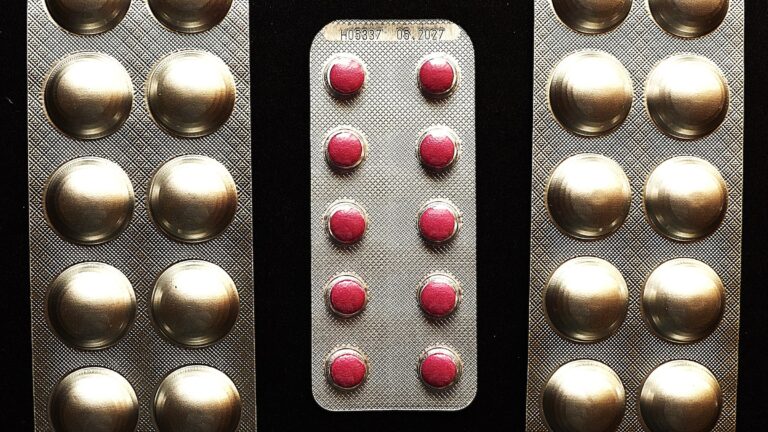 Blister packs of tablets on a dark surface