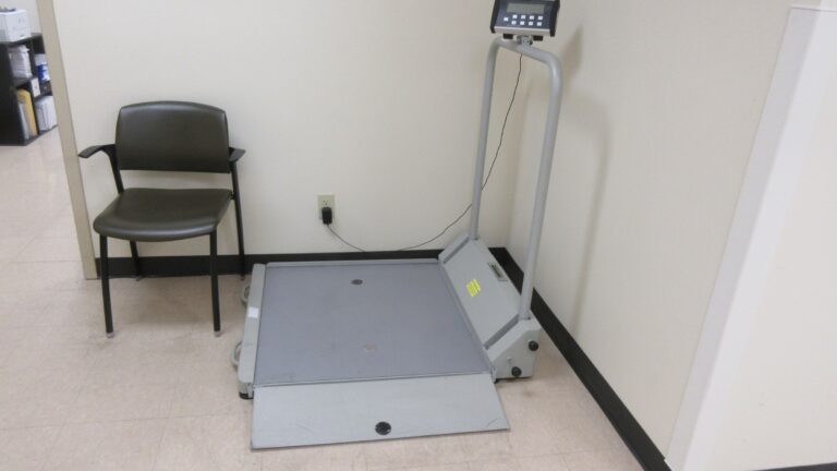 Empty medical consulting room with a floor-mounted weighing scale